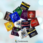 A lively Flavored Condom Sampler from Condomania, featuring a diverse array of colorful packages in a scattered arrangement, showcases an enticing selection of flavors like banana, chocolate, strawberry, and vanilla. Ideal for enhancing intimate moments, the Condomania logo is elegantly displayed at the bottom against a softly blurred light background.